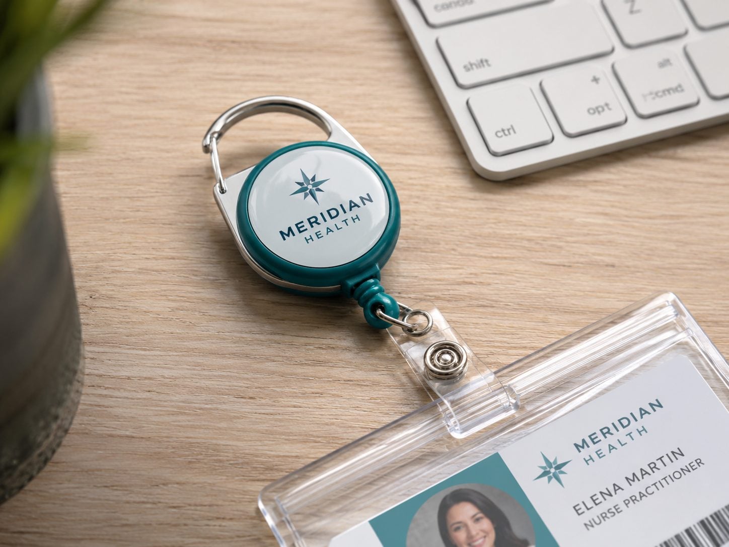 Full-color printed carabiner badge reel with an invented brand logo clipped to a field technician belt loop